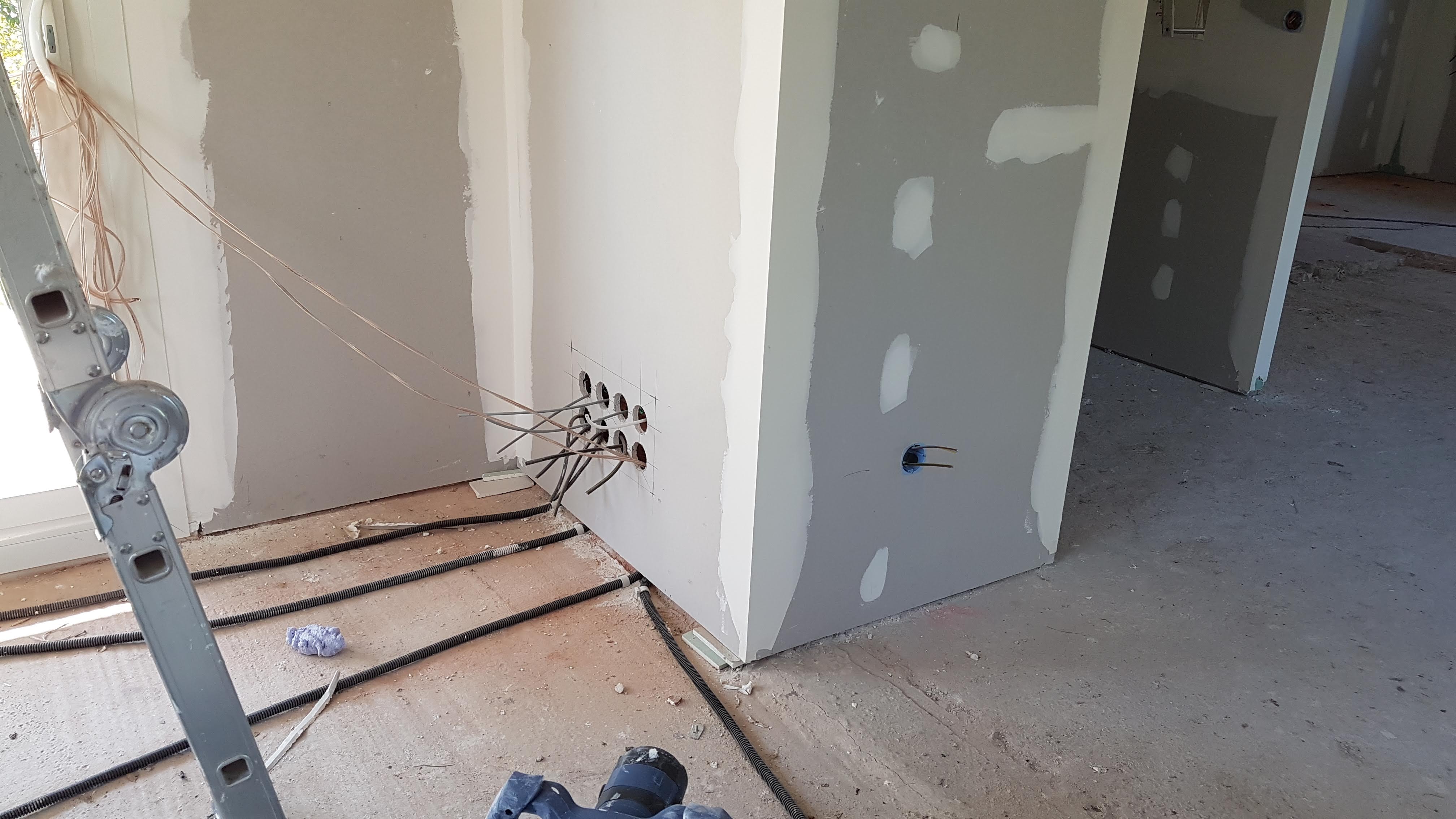 Mur avec boîtes électriques et protections de chantier pendant une rénovation